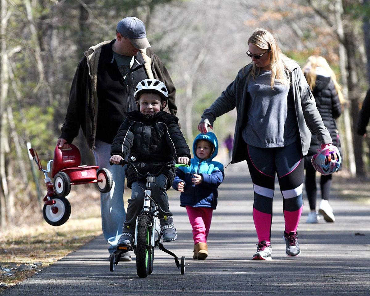 Anna and Tom Jablonski of New Ipswich take a walk with their children, Timothy, 5, and Ariana, 2, on the Londonderry Rail Trail on Wednesday.